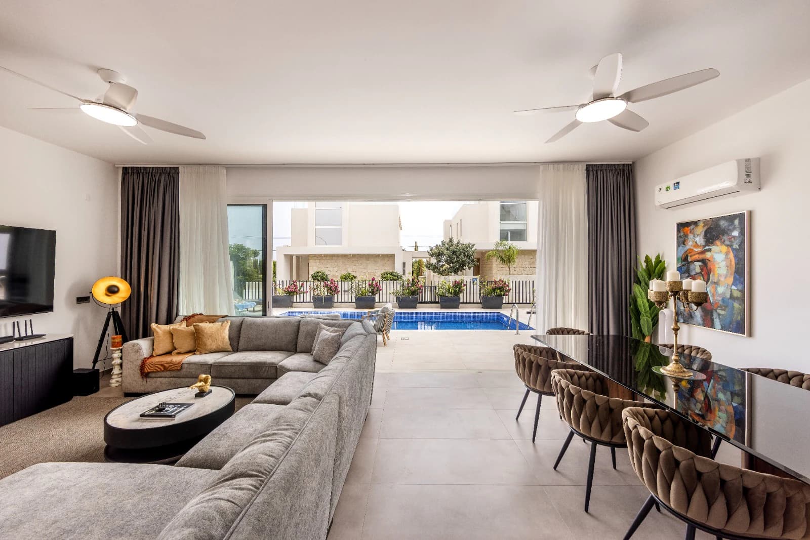 The living room looking out through open glass doors to the pool.